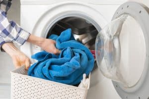hand put clothes in washing machine